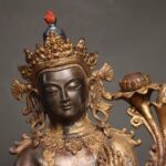 Ornate multi-lobed crown topped with red jewel finial, spiral dangling earrings, naturally abraded gilding statue