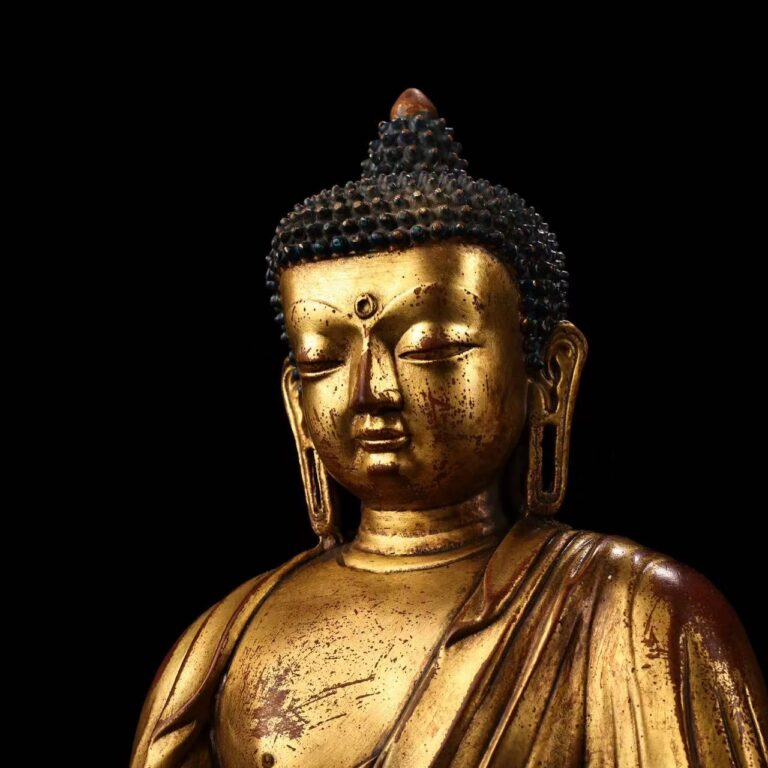 Close-up of the solemn face of antiqued Medicine Buddha statue